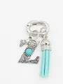 Macro view of bohemian silver letter Z bag charm with turquoise stone and blue tassel - Letter Z