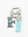 Close-up of silver letter F charm featuring turquoise stone and light blue tassel - Letter F