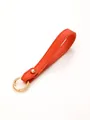 Close-up of bright orange pebbled leather wristlet keychain strap with gold ring - Orange