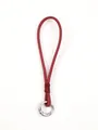 Close-up view of a red leather phone wrist strap lanyard with a silver metal ring - True Red