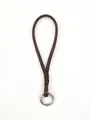 Detailed close-up of a handmade brown leather phone wrist strap with a silver metal spring ring - Dark Brown