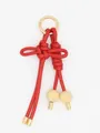 Detalle de un llavero de cuero PU trenzado rojo con nudo y cuentas de madera fina. - Rojo