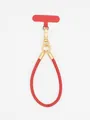 Macro view of stylish red PU leather phone wrist strap featuring a golden metal buckle - Red