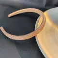 Primo piano del cerchietto strass oro champagne che mostra la trama dei diamanti - Champagne