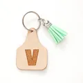 Minimalist leather cow tag keychain featuring engraved letter V and mint green tassel charm - Letter V Style (20452)