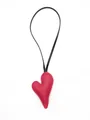 Detail macro view of a red pebbled leather heart-shaped bag charm with black strap - Heart Charm / Red