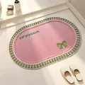 Elegant pink oval linen-texture bathroom mat featuring a green bow and BATHROOM print - 40*60cm / Pink and Green-Oval