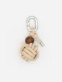 Close-up detail of a beige handmade woven PU ball keychain with a silver metal carabiner - Woven Ball Charm (22625)