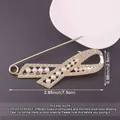 Detailed macro view of gold ribbon brooch with pearls including size measurements info - Hollow Streamlined / Gold