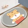 Hochwertige Diatomeenerde-Badematte mit süßem Comic-Tiger-Design in einer Badezimmerumgebung - 40*60cm / Blinzelnder Glücklicher Tiger (Oval)