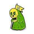Cute cartoon enamel skull brooch pin featuring a green robe and a tiny yellow flag - Yellow Skeleton with Cape Brooch (JEWB-E029-02EB-01)