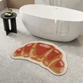 Croissant-shaped tufted bath mat in a modern bathroom setting next to a bathtub - 40*60cm / Croissant