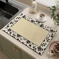 Detailed view of an absorbent kitchen mat with elegant black floral borders. - Faman Floral