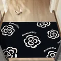 Non-slip black silk loop entrance mat featuring white camellia floral pattern and Camellia text - Black Camellia (HD-7)