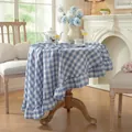 Close-up of blue and white gingham round tablecloth with elegant ruffled edge detail - 120cm / Blue