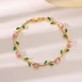 Eleganter goldener Rankenarmreif mit funkelnden rosa und grünen Zirkonia-Steinen - Rosa und Grüner Zirkonia Reben Stil (DQ-W-3740) / Gold