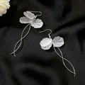 Elegant white multi-layered petal drop earrings featuring long silver curved wire tassels. - Long Flower Tassel (7081)