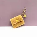 Close-up of a cute yellow plush coin purse keychain with soft wooly texture and golden hook. - Single Piece / Yellow