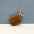 Detail of a brown sherpa fleece coin purse featuring a gold keychain and tassel accessory - Single Piece / Brown