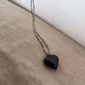 Macro shot of a black heart pendant necklace with silver rice beads on textured linen - Heart Double Chain Necklace / Black