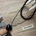 Elegant double-layer black beaded necklace with a glossy heart pendant on wood background - Black Artificial Pearl Necklace and Black Heart Necklace Set / Black