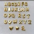 Detailed view of mini gold alphabet pendants and symbols with a smooth polished finish - Letter A / Gold