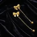 Elegant golden bow-knot tassel drop earrings with long chain design on black velvet - Bow Combination / Gold