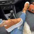 Stylish brown platform sneakers for women featuring thick white soles in a car interior setting. - 36 / Bronze