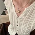 Elegant silver-plated lariat necklace with gold gourd pendant over cream knit cardigan - Gold Gourd Style