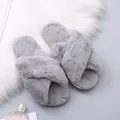Detailed macro view of soft grey plush criss-cross slippers on a white faux fur rug - 36 / Gray