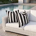 Pair of premium black and white wide striped outdoor pillowcases on white wicker sofa near pool - Black Medium Stripes