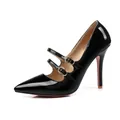 Close-up view of elegant black patent leather high heels with double gold buckle straps. - 34 / Black