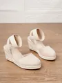 Primer plano de sandalias de cuña beige para mujer con suelas de esparto de yute clásicas - Albaricoque