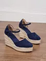 Close-up of navy blue suede wedge sandals featuring a braided jute platform and ankle strap. - 34 / Dark Blue