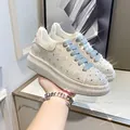 Detailed view of sparkling rhinestone platform sneakers featuring stylish blue-grey laces - 38 / Silver