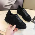 Detail shot of black women's rhinestone platform sneakers with glittery laces. - 35 / Black