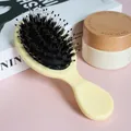 Close-up of a cream-colored boar bristle massage hairbrush for detangling hair - Yellow