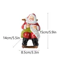 Statua Babbo Natale in resina su sedia a dondolo con dimensioni 15cm x 14cm x 8.5cm - Babbo Natale sulla Sedia a Dondolo che Scrive la Lista (RRW142-2)