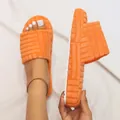 Detail of orange terry cloth slippers showing thick white sole and embossed pattern - 35 / Orange