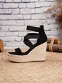 Side view of women's black elastic strap wedge sandals with a woven straw platform base. - 34 / Black