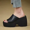 Close-up side view of black platform wedge slide sandals with thick sole on model foot. - 34 / Black