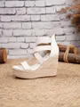 Detail view of white platform wedge sandals with elastic straps and espadrille jute heel. - 34 / White