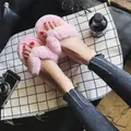 Detailed shot of fluffy pink plush thong slippers worn on feet with grid background - 36-37 / Pink