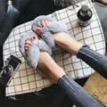 Detailed view of plush grey faux fur flip-flop slippers styled with casual denim jeans - 36-37 / Gray