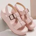 Close-up view of pink platform Roman sandals featuring a gold buckle and T-strap - 36 / Pink