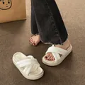 Detail showing white cross-strap platform slides on textured carpet background. - Off White