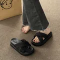 Detail shot of black platform sandals with textured cross-over straps on carpet - 35 / Black