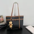 Large black minimalist faux leather tote bag featuring brown trim and a cute bear charm - With Pendant / Black