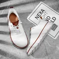 Détail de baskets blanches en fly-knit respirant pour hommes avec cuir marron. - 40 / Blanc