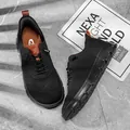 Vue détaillée de chaussures décontractées en maille fly-knit noire sur un fond en pierre grise - 40 / Noir